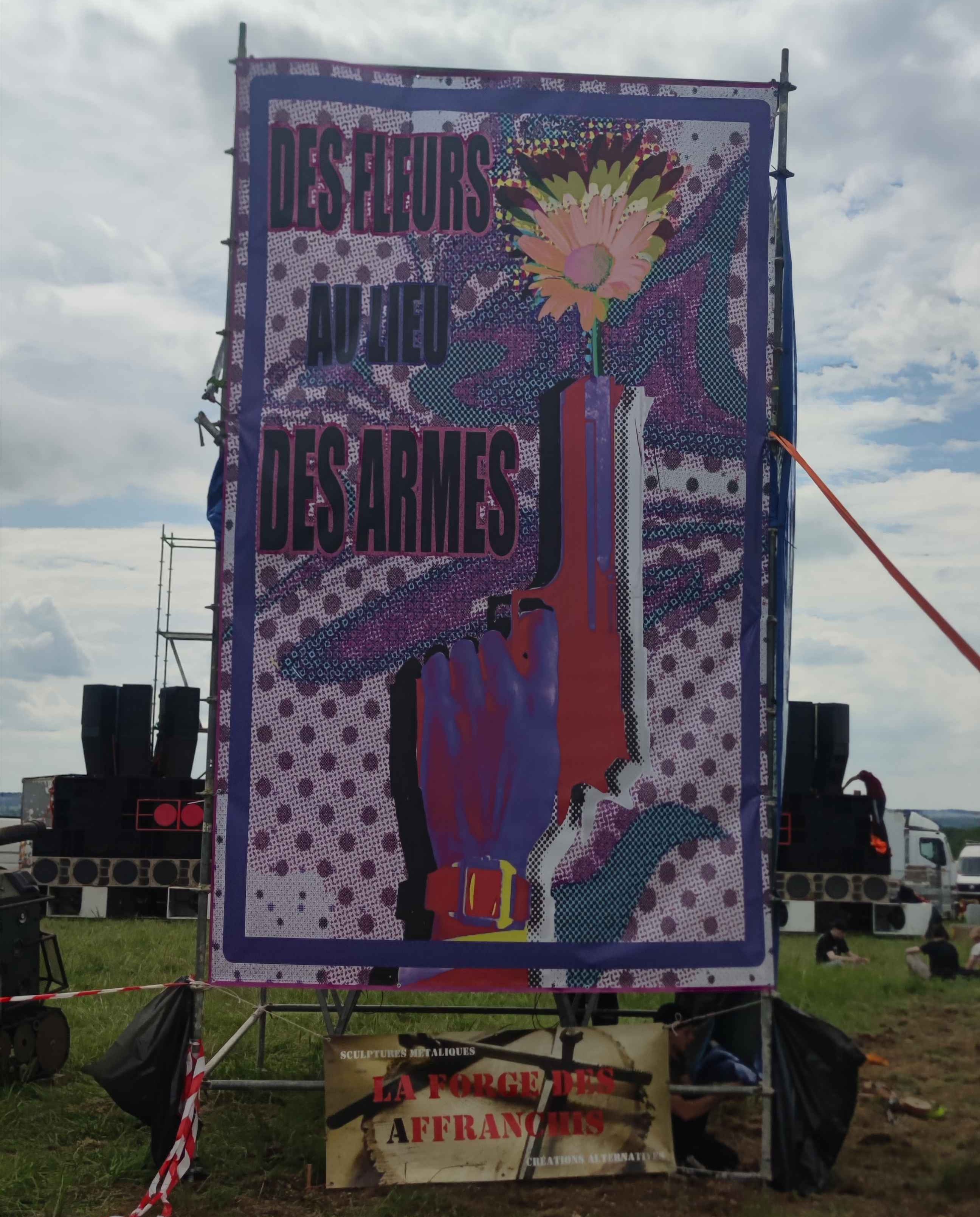 Grande affiche avec 'des Fleurs au lieux des Armes' écrit dessus.